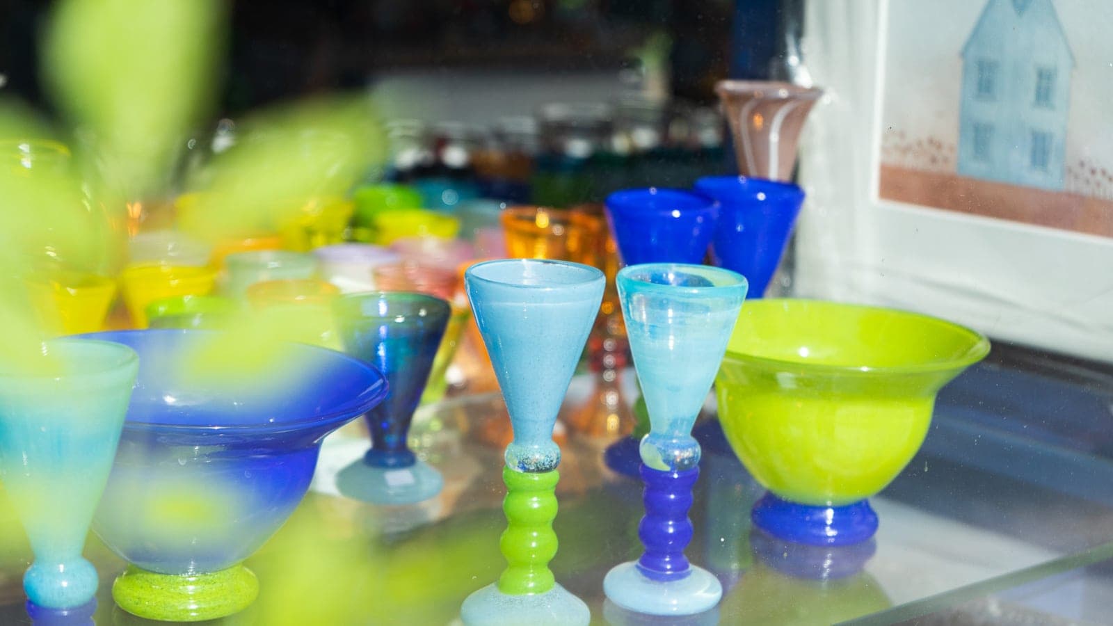 Fargerike kunstglass i grønt og blått i vinduet til et galleri
