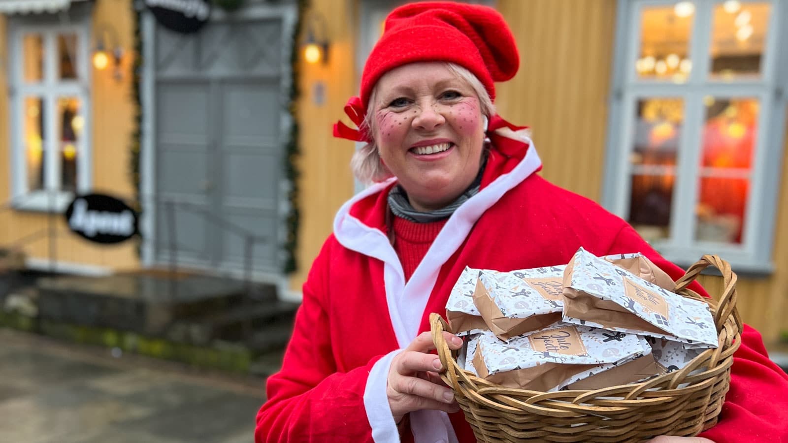 Dame som er utkledd som nissemor som holder julegodteri