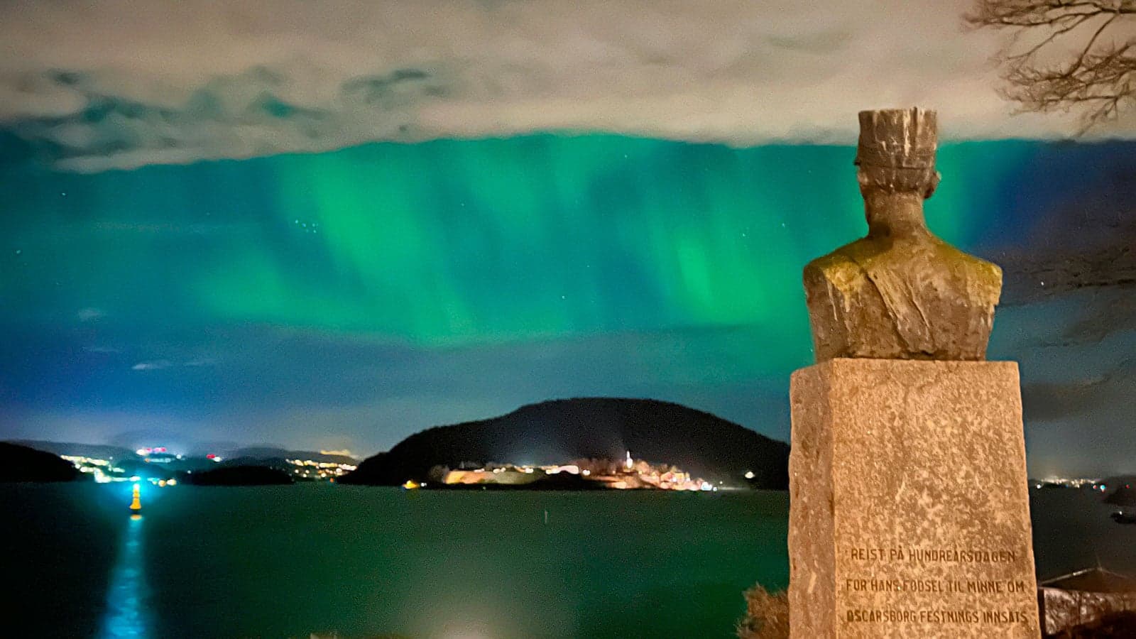 Nordlys foran en statue